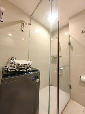 a bathroom with a shower and a refrigerator at Uptown BGC 1BR Modern Pool View Unit by Terravista in Manila