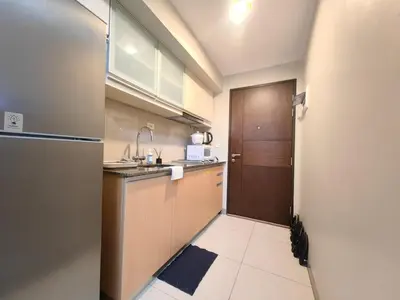 a small kitchen with a sink and a refrigerator at Uptown BGC 1BR Modern Pool View Unit by Terravista in Manila