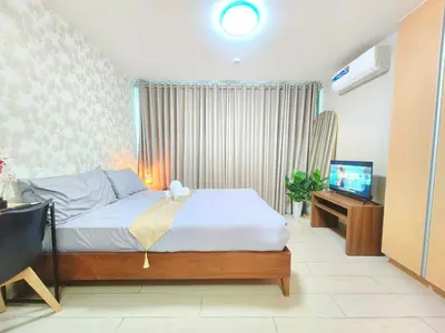 a bedroom with a bed and a flat screen tv at Uptown BGC 1BR Modern Pool View Unit by Terravista in Manila