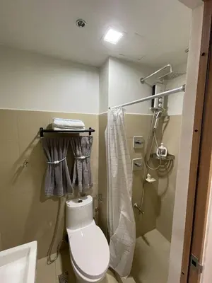 a small bathroom with a toilet and a shower at Luxury Staycation at Shore 3 Mall of Asia in Manila