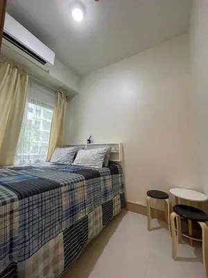 a bedroom with a bed and two chairs and a window at Luxury Staycation at Shore 3 Mall of Asia in Manila