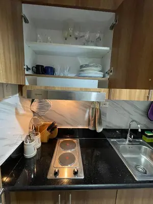 a kitchen counter with a stove and a sink at Luxury Staycation at Shore 3 Mall of Asia in Manila