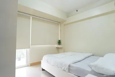 a white bedroom with a bed and a window at Solemare Parksuites - Condo In Parañaque Near MOA ARENA, SMX CONVENTION CENTER AND DFA MAIN OFFICE in Manila