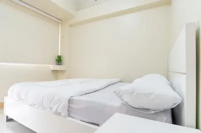 a white bedroom with two beds and a mirror at Solemare Parksuites - Condo In Parañaque Near MOA ARENA, SMX CONVENTION CENTER AND DFA MAIN OFFICE in Manila