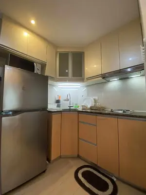 a kitchen with a stainless steel refrigerator and cabinets at Bekipay Suite at Two Palm tree across NAIA 3 in Manila