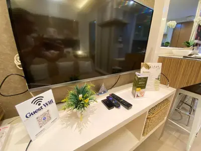 a room with a tv and a table with remote controls at Bekipay Suite at Two Palm tree across NAIA 3 in Manila