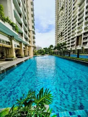 a large blue swimming pool between two tall buildings at Vtan Condo FAIRLANE PASIG in Manila