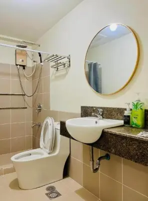 a bathroom with a toilet and a sink and a mirror at Vtan Condo FAIRLANE PASIG in Manila