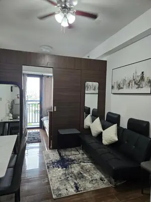 a living room with a black couch and a table at Air Residences Makati in Manila