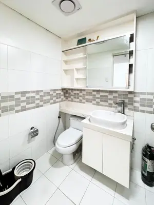 a white bathroom with a toilet and a sink at Vanity Calm Bedroom in Ortigas Center in Manila