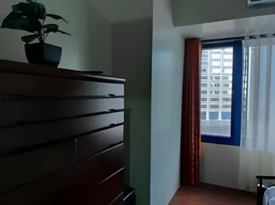 a bedroom with a dresser and a window at Makati Staycation at Air Residences in Manila