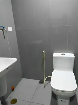 a white bathroom with a toilet and a sink at Makati Staycation at Air Residences in Manila
