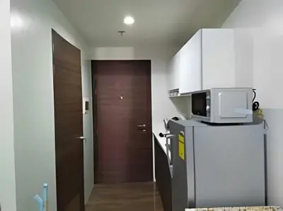 a small kitchen with a microwave and a refrigerator at Makati Staycation at Air Residences in Manila
