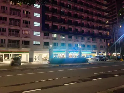 a building at night with cars parked in front of it at Sea residences Christine prime in Manila