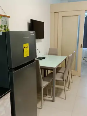 a dining room with a table and a refrigerator at Sea residences Christine prime in Manila