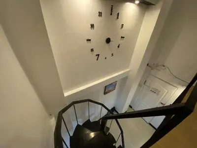 a staircase with a clock on the wall at Adorable - 2A, Chill Room in Manila
