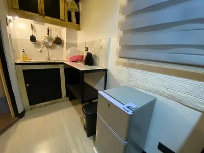 a small kitchen with a sink and a refrigerator at Adorable - 2A, Chill Room in Manila