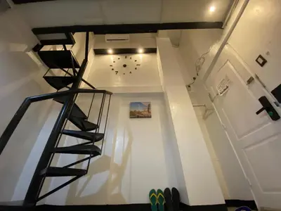 a staircase in a house with a clock on the wall at Adorable - 2A, Chill Room in Manila