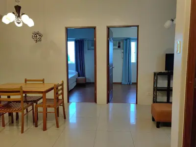 a dining room and living room with a table and chairs at Apartment in Rhapsody 2BR in Manila