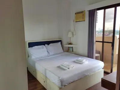 a bedroom with a bed with two towels on it at Apartment in Rhapsody 2BR in Manila