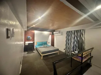a small bedroom with a bed and a desk at Adorable - 2B, Stunning Lounge in Manila