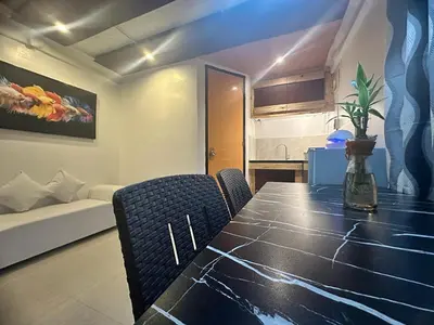 a dining room table and chairs in a room at Adorable - 2B, Stunning Lounge in Manila
