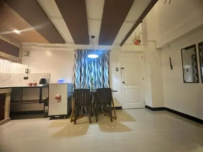 a kitchen with two chairs and a table in a room at Adorable - 2B, Stunning Lounge in Manila