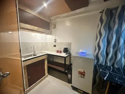 a small kitchen with a sink and a refrigerator at Adorable - 2B, Stunning Lounge in Manila