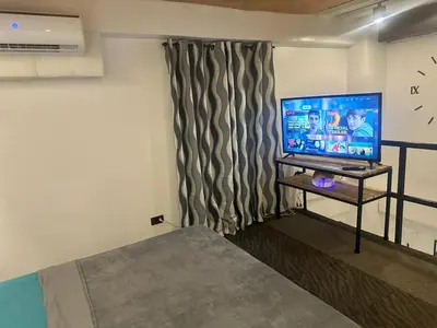 a room with a flat screen tv on a table at Adorable - 2B, Stunning Lounge in Manila