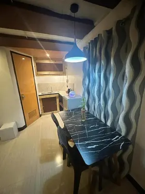 a dining table in a kitchen with aendant light at Adorable - 2B, Stunning Lounge in Manila