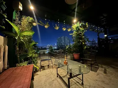 a patio with a glass table and some plants at Adorable - 2C, Love Nest Studio unit in Manila