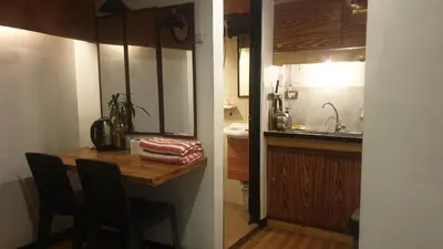 a small kitchen with a wooden table and a sink at Adorable - 2C, Love Nest Studio unit in Manila