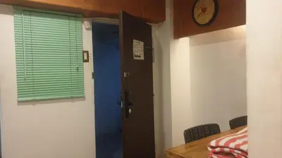 a room with a door and a table and a clock at Adorable - 2C, Love Nest Studio unit in Manila