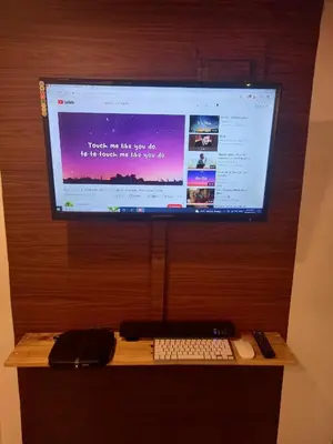 a computer monitor on a wooden wall with a keyboard and mouse at Adorable - 2C, Love Nest Studio unit in Manila