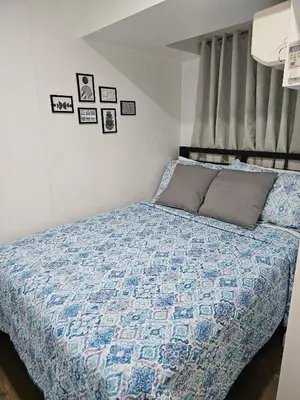 a bedroom with a bed with a blue quilt at Casa Rosa3 2BR loft in BGC 5 people in Manila