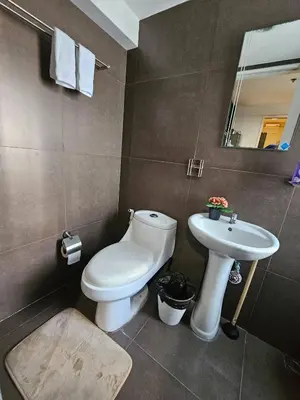 a bathroom with a toilet and a sink at Casa Rosa3 2BR loft in BGC 5 people in Manila