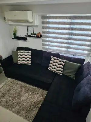a black leather couch in a living room with a window at Casa Rosa3 2BR loft in BGC 5 people in Manila