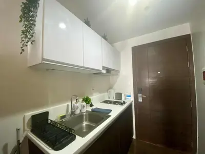 a kitchen with a sink and a counter top at SOLACE by Athena at Air Residences Makati in Manila