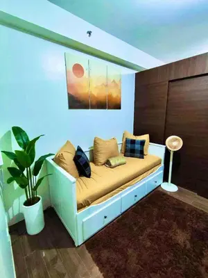 a couch with pillows on it in a room at SOLACE by Athena at Air Residences Makati in Manila