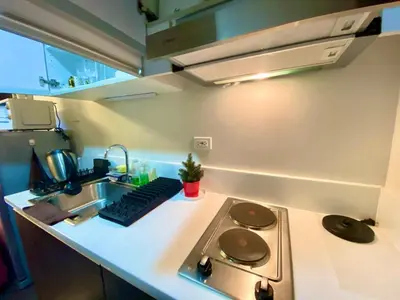a kitchen counter with a stove and a sink at SOLACE by Athena at Air Residences Makati in Manila