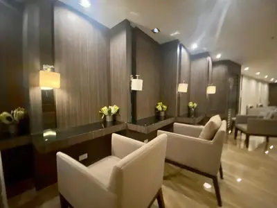 a waiting room with white chairs and a mirror at SOLACE by Athena at Air Residences Makati in Manila