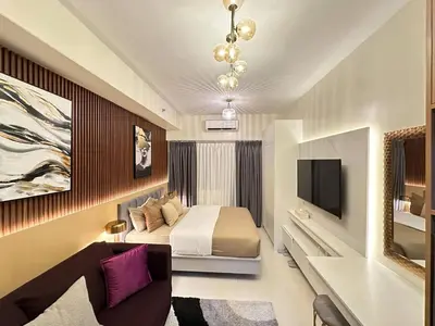 a hotel room with a bed and a tv at Red Residences in Manila