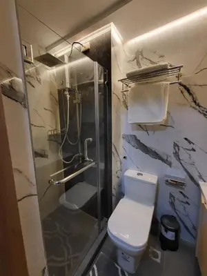 a bathroom with a shower and a toilet and a sink at Red Residences in Manila
