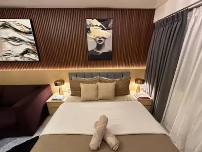 a bedroom with a bed and two pictures on the wall at Red Residences in Manila