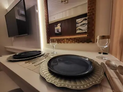 a table with two black plates and wine glasses at Red Residences in Manila