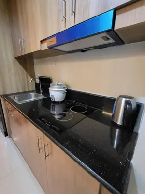 a kitchen counter with a stove and a sink at Red Residences in Manila
