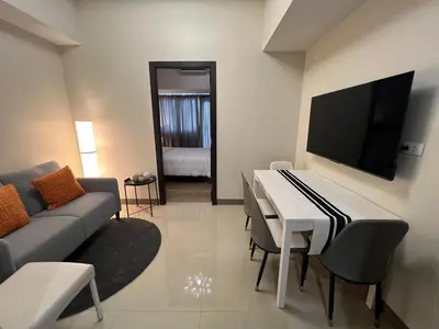a living room with a couch and a piano at Parkwest McKinley - 1 Bedroom Fully Furnished in Manila