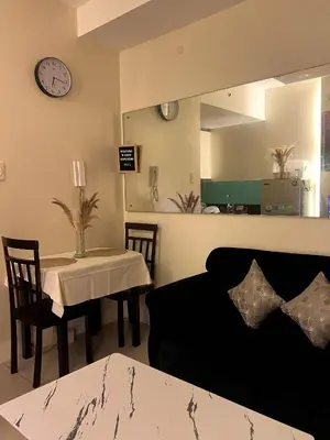 a living room with a couch and a table and a mirror at MOA Shell Residences Staycation in Manila