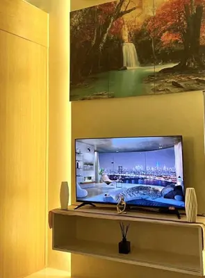 a tv sitting on a shelf in a room at MOA Shell Residences Staycation in Manila
