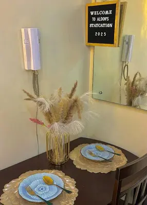 a table with two plates and a vase with flowers at MOA Shell Residences Staycation in Manila